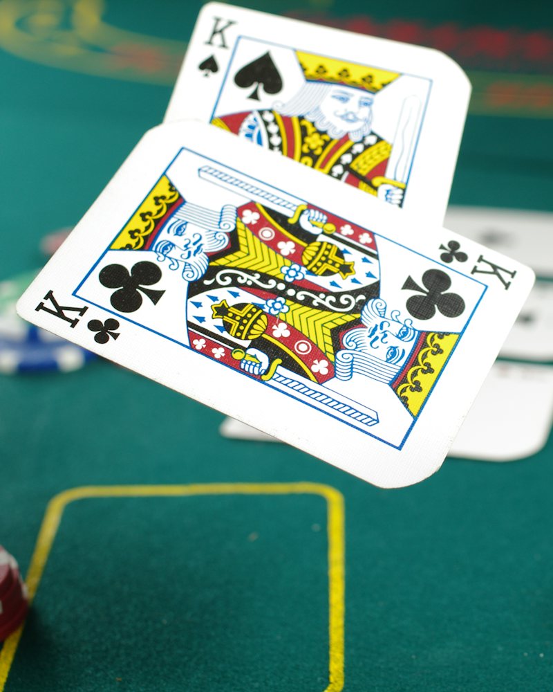 Dua kad King melayang di atas meja kasino hijau